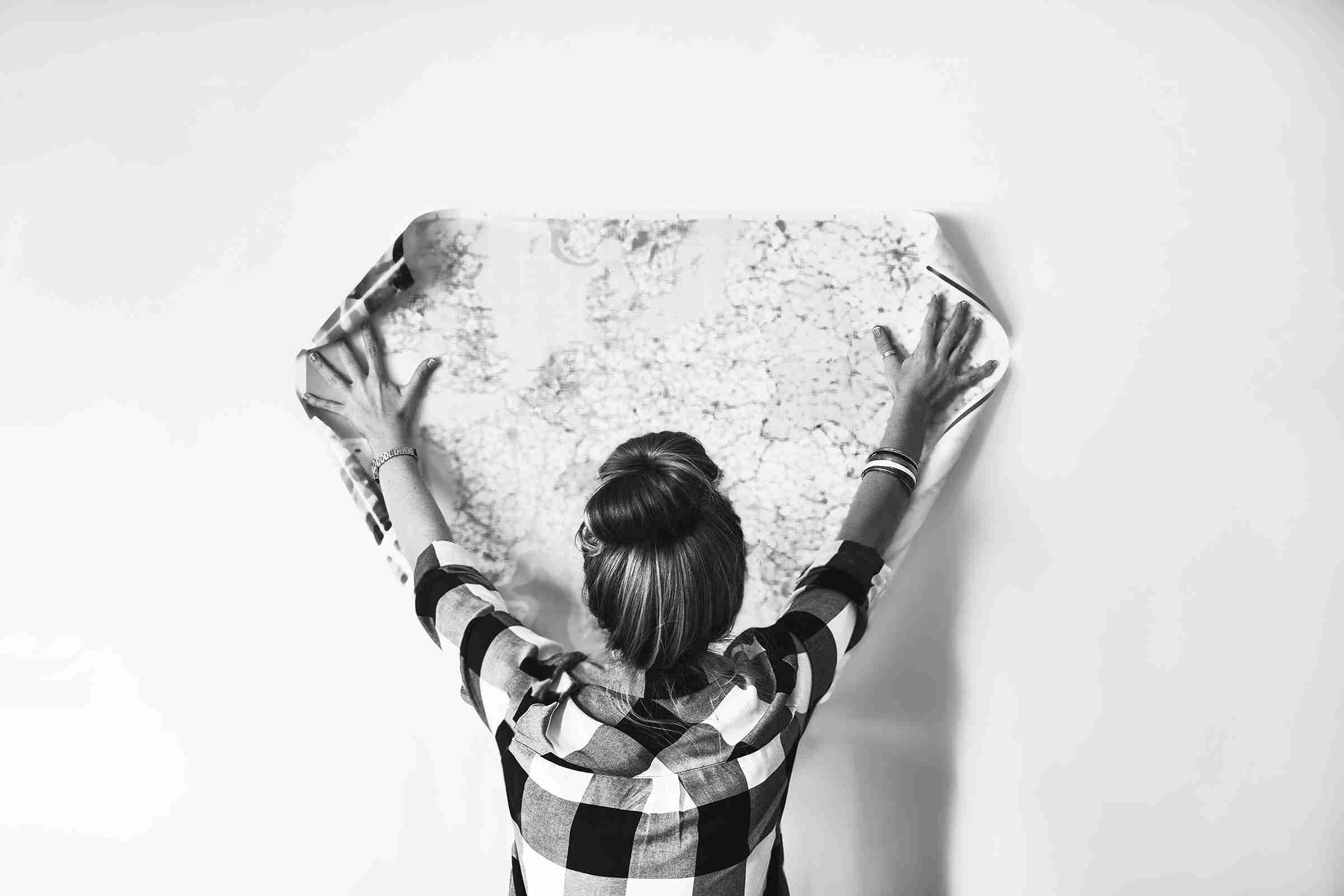 Woman sticking paper on wall