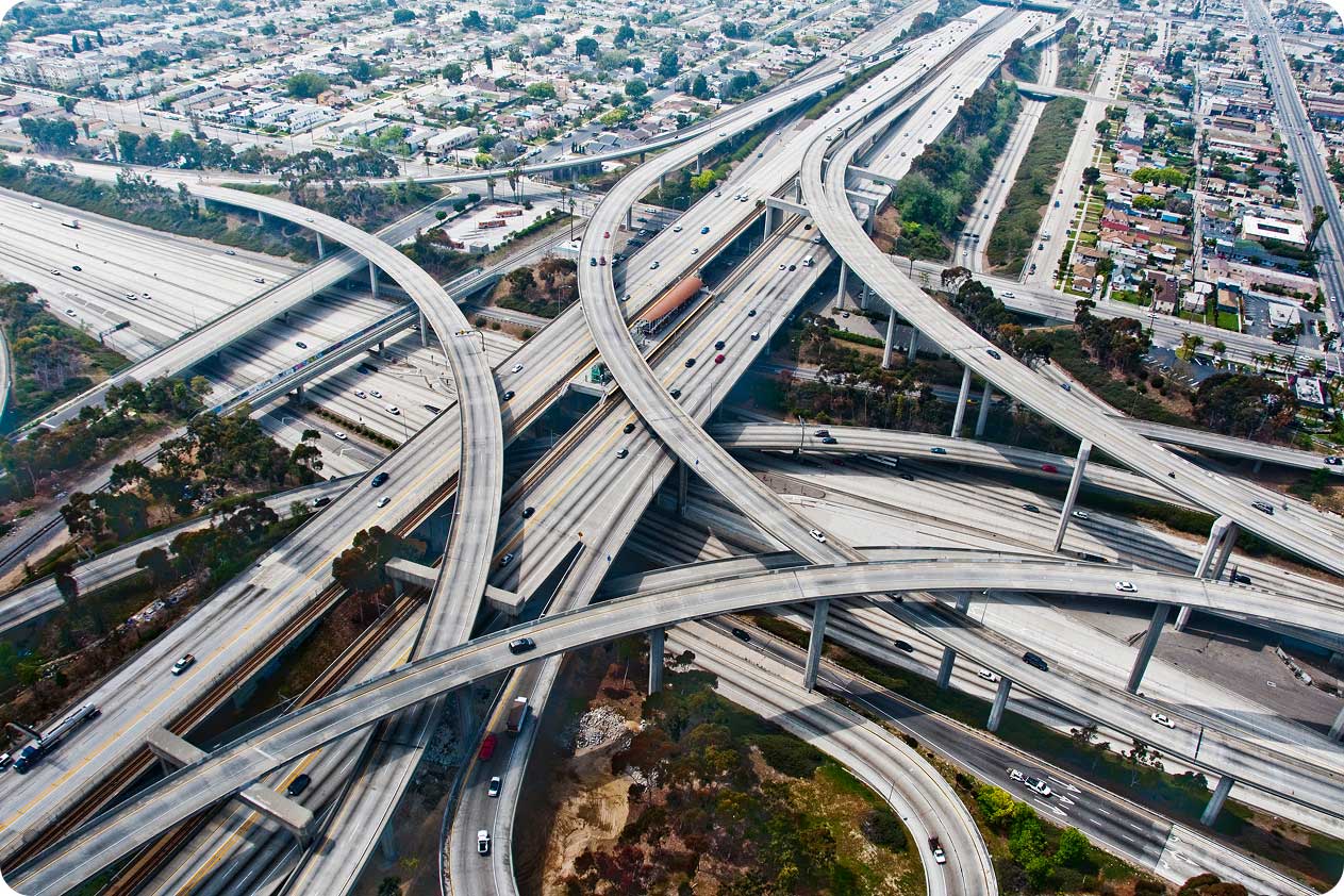 Aerial view of a large multi-level highway interchange with overpasses, ramps, and vehicles traveling in different directions