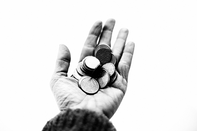 Image of a person holding coins in their hand.