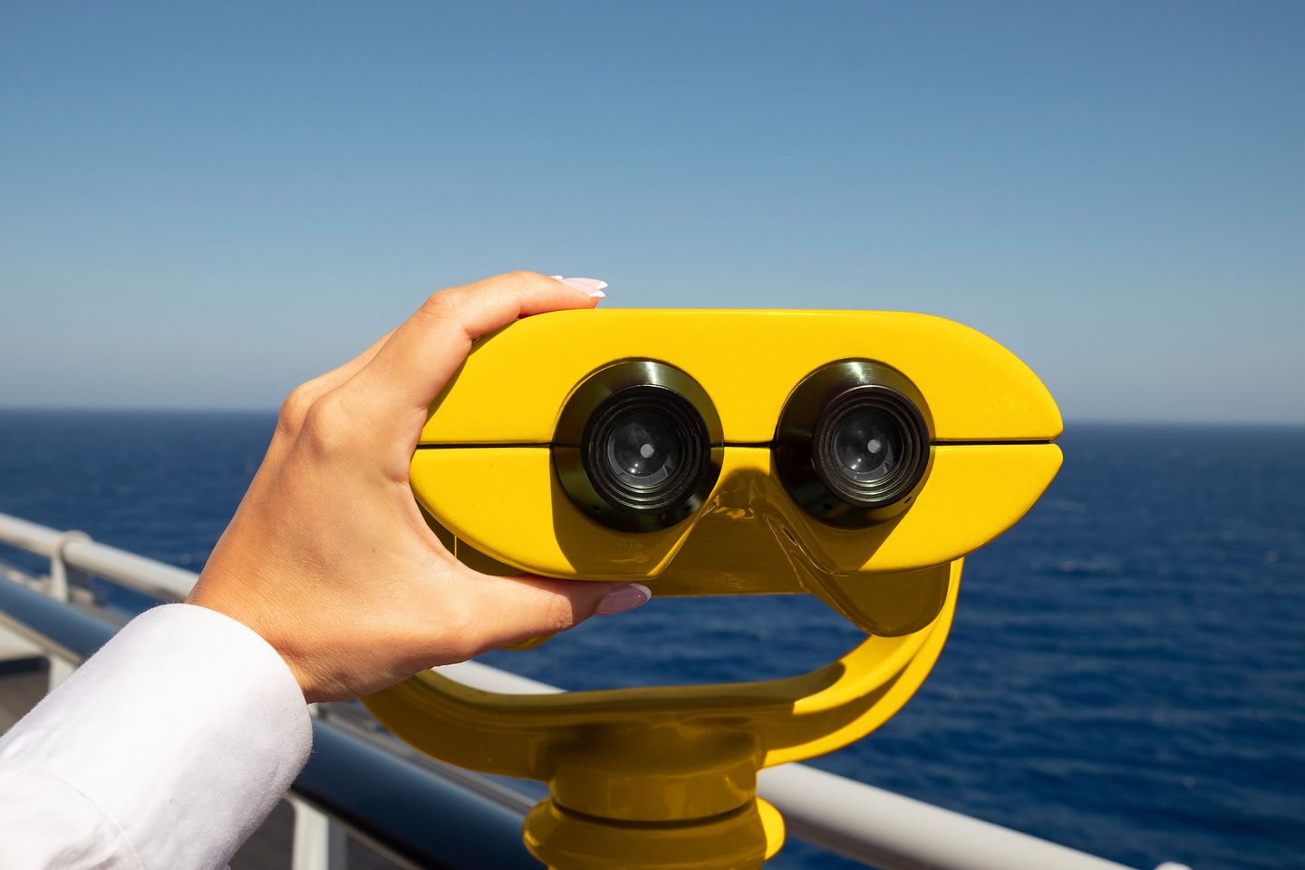 yellow binoculars overlooking the ocean on a sunny day