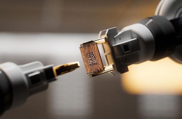 Close-up of robotic arms positioning a microchip component during a precision technology or semiconductor manufacturing process.