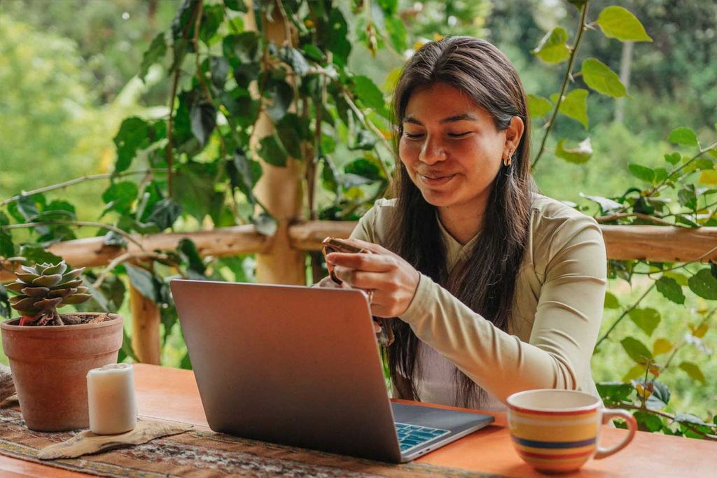 Eine junge Frau sitzt vor ihrem Laptop