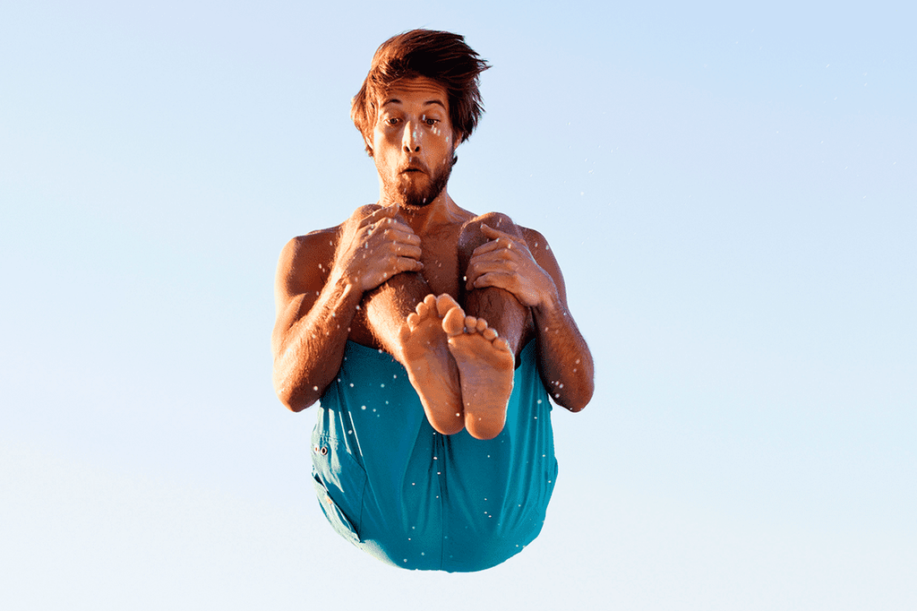 Image of a man jumping into a swimming pool.