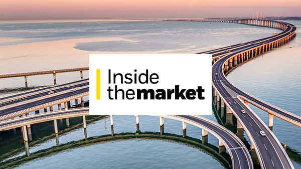 An aerial view of curving bridge structure stretching across a wide body of water.